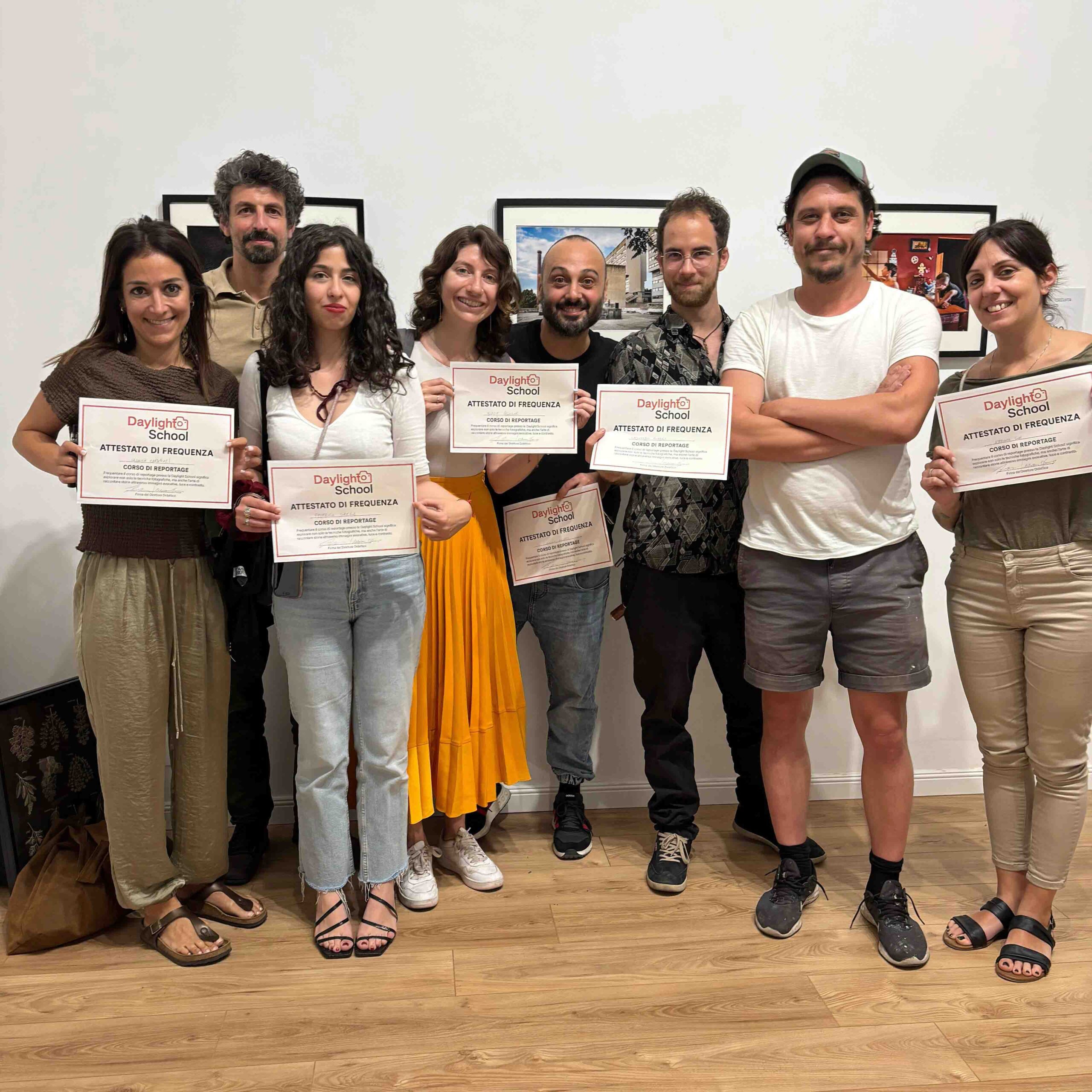 Allievi mostrano l'attestato di frequenza del corso di reportage alla Daylight School, scuola di fotografia a Roma.