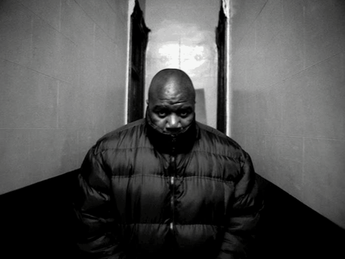 Black-and-white still from the video "99 Problems," a close-up of a man in a hallway